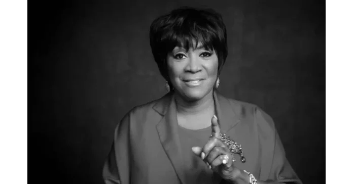 Arleata Williams smiling in professional portrait wearing elegant blazer with brooch