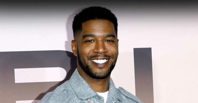 Lindberg Mescudi smiling confidently at a public event, wearing a stylish grey jacket.