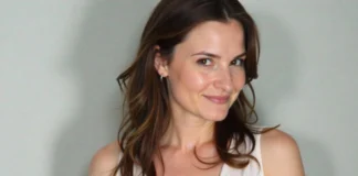 Portrait of actress Dylan Tays, known for her 1990s TV and music video roles, smiling against a neutral background.