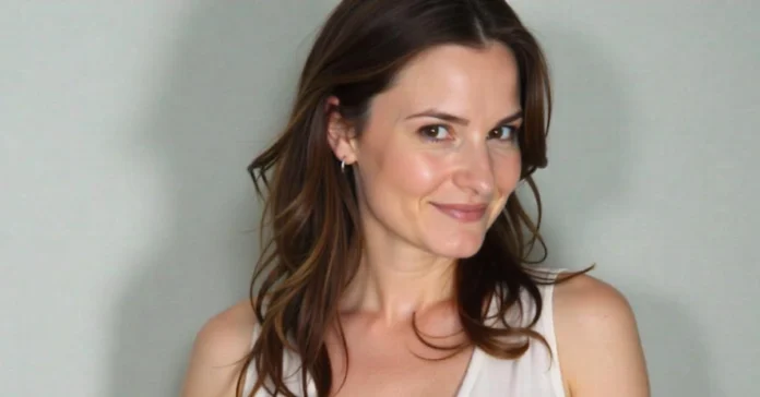 Portrait of actress Dylan Tays, known for her 1990s TV and music video roles, smiling against a neutral background.