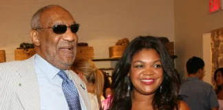 Evin Harrah Cosby attending a social event, standing beside a man in a light suit, with guests and woven baskets in the background.