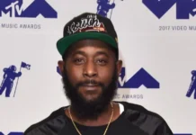 Karlous Miller smiling on stage, holding a microphone, representing Karlous Miller Net Worth and his success in comedy and entertainment.