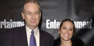 Maureen E. McPhilmy attends an Entertainment Weekly event, standing alongside a companion in formal attire before a branded backdrop.