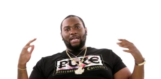Peezy Rapper performing on stage in Detroit, engaging the crowd with his energetic presence and signature hip-hop style.