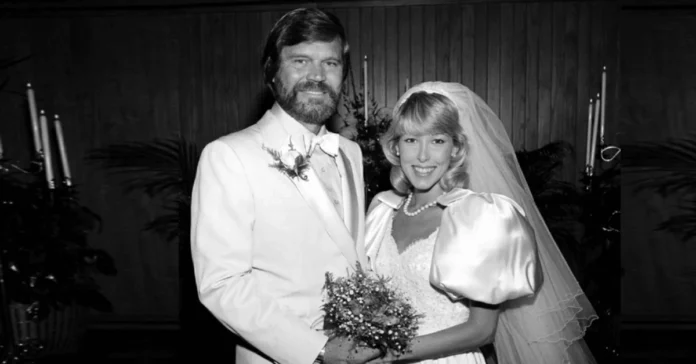 Glen Campbell and Sarah Barg wedding photo from 1976 showing the couple in white attire with Sarah wearing a pearl necklace and veil.