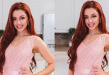 Vanna Bardeau smiling in a delicate pink lace dress with diamond jewelry, showcasing her signature red hair and elegant style in a modern kitchen setting