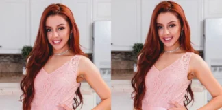 Vanna Bardeau smiling in a delicate pink lace dress with diamond jewelry, showcasing her signature red hair and elegant style in a modern kitchen setting