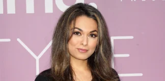 Aishah Hasnie, acclaimed Fox News correspondent, poses confidently at media event with stylish hair and professional appearance against pink backdrop