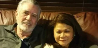Nila Ermey sitting on a brown leather couch with her husband, sharing a quiet moment at home.