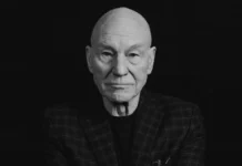 Patrick Stewart seated confidently in a stylish blazer, embodying his iconic presence as a legendary actor in film and television.