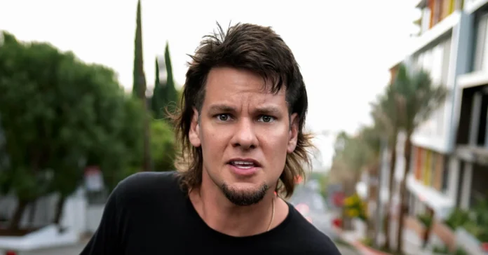 Alt Text: Theo Von looking intensely at camera with his signature mullet - the comedian whose net worth reflects his journey from MTV to podcasting millionaireRetryClaude can make mistakes. Please double-check responses.