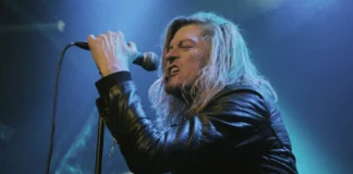 Wes Scantlin performing live on stage with microphone, Puddle of Mudd frontman whose net worth reached $500K in 2025