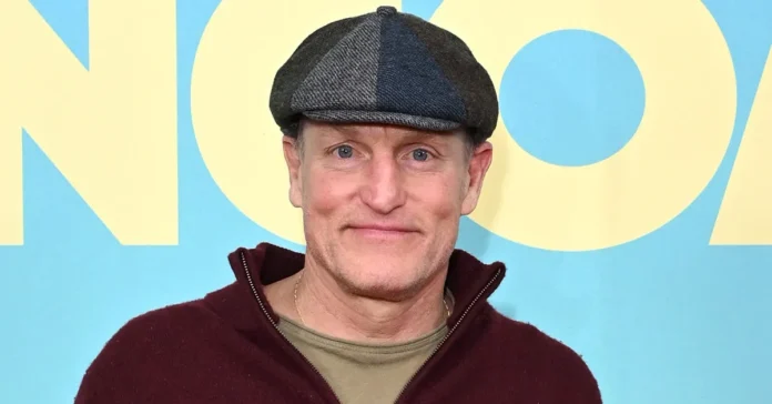 Woody Harrelson at premiere event wearing signature flat cap and burgundy hoodie, embodying the casual wellness-focused lifestyle of the Hollywood actor